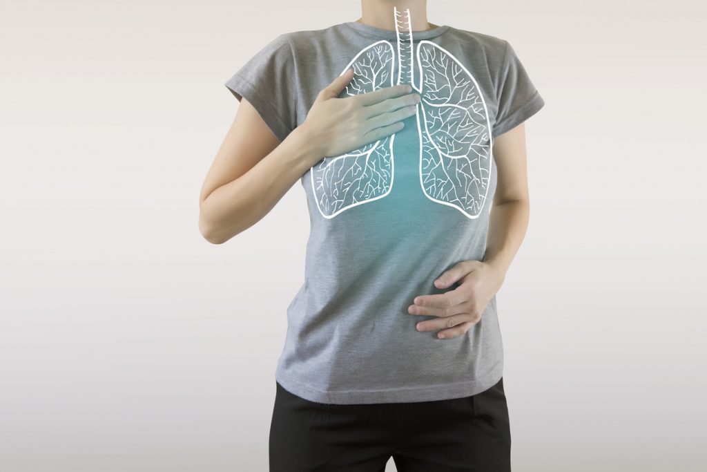 person gripping chest, x-ray graphic of lungs in chest